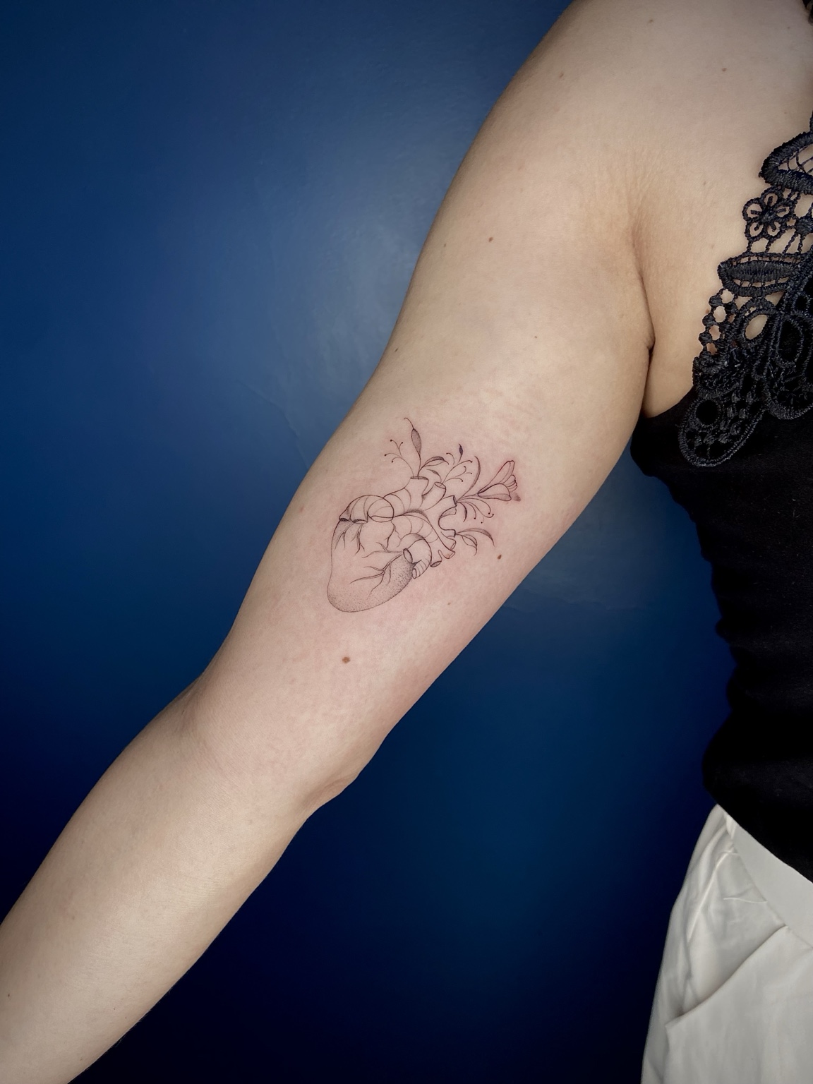 Tatuagem delicada de coração anatômico floral