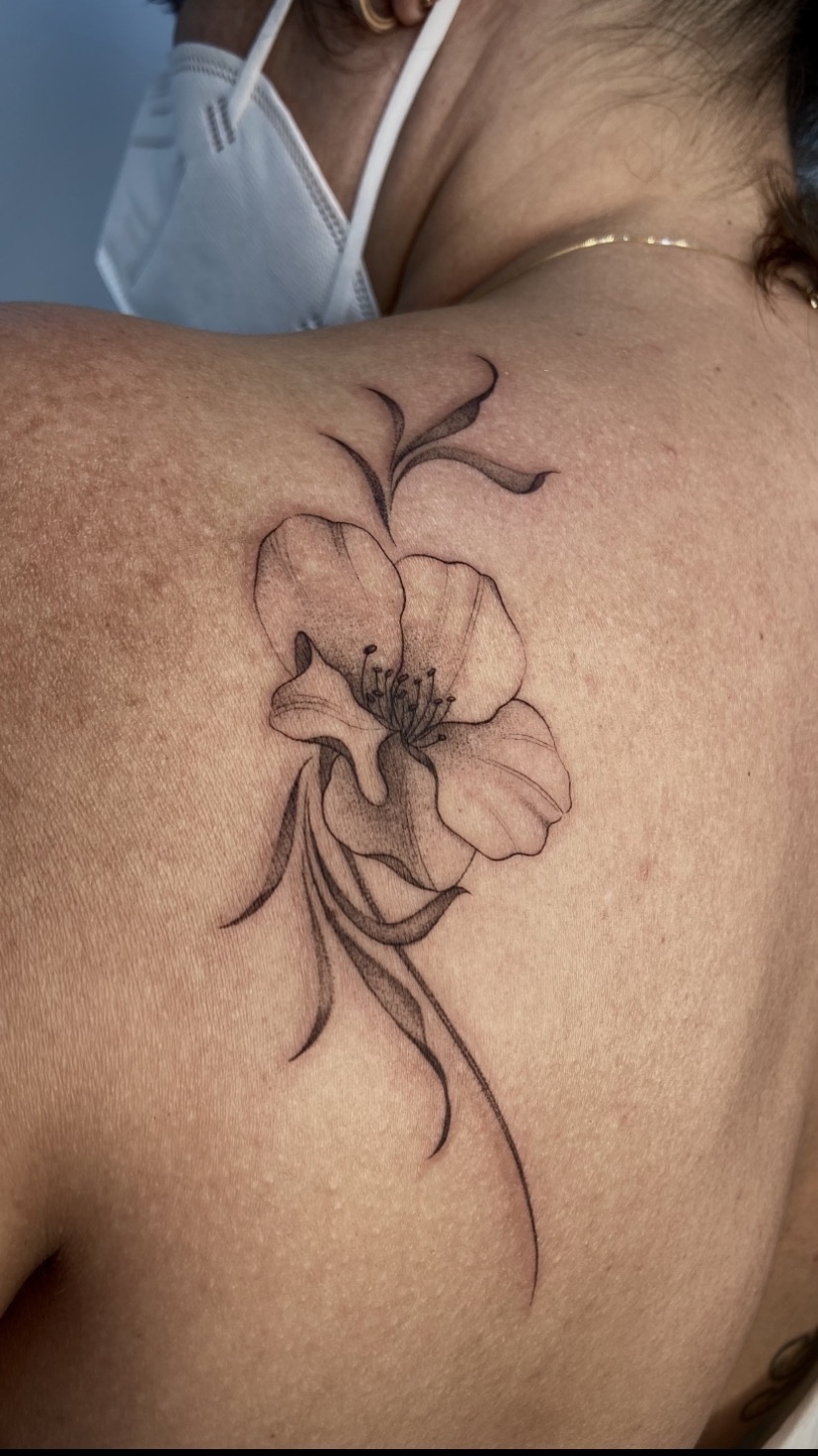 Tatuagem floral delicada sobre o ombro