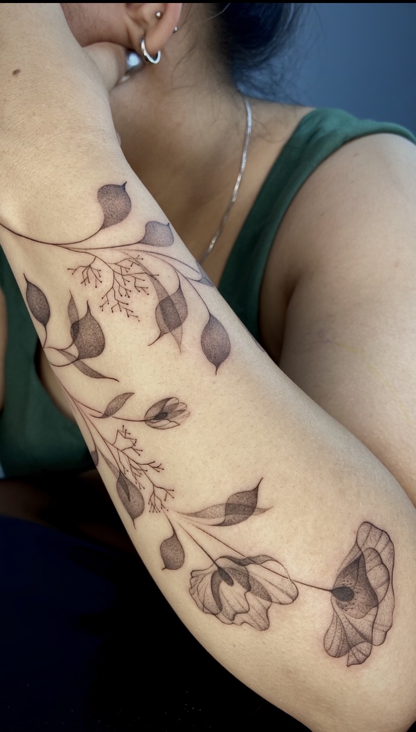 Tatuagem botânica transparente envolvendo o braço