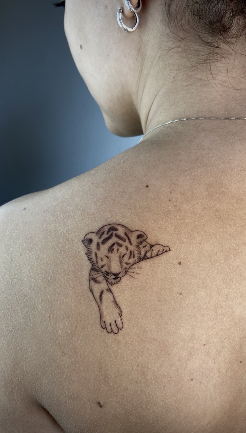 Tatuagem delicada de filhote de tigre sobre o ombro