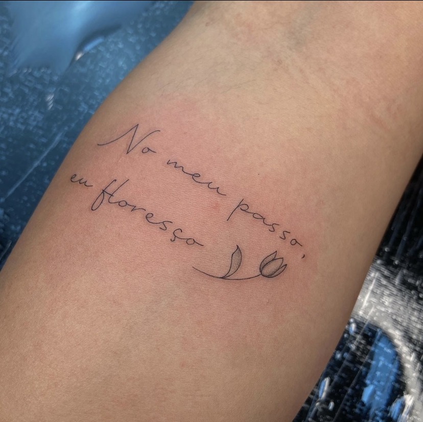 Tatuagem de frase com pequena tulipa